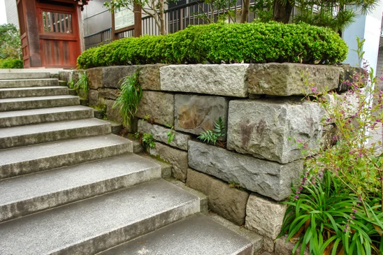 Am&eacute;nagement paysager ext&eacute;rieur avec escalier en b&eacute;ton et mur de sout&egrave;nement en blocs de pierre naturelle