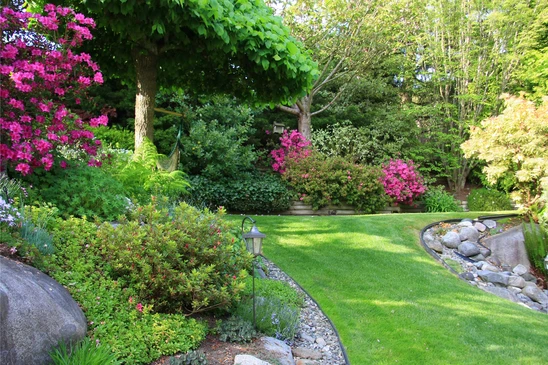 Jardinier professionnel am&eacute;nageant un jardin paysager ext&eacute;rieur, construisant un muret en pierres naturelles