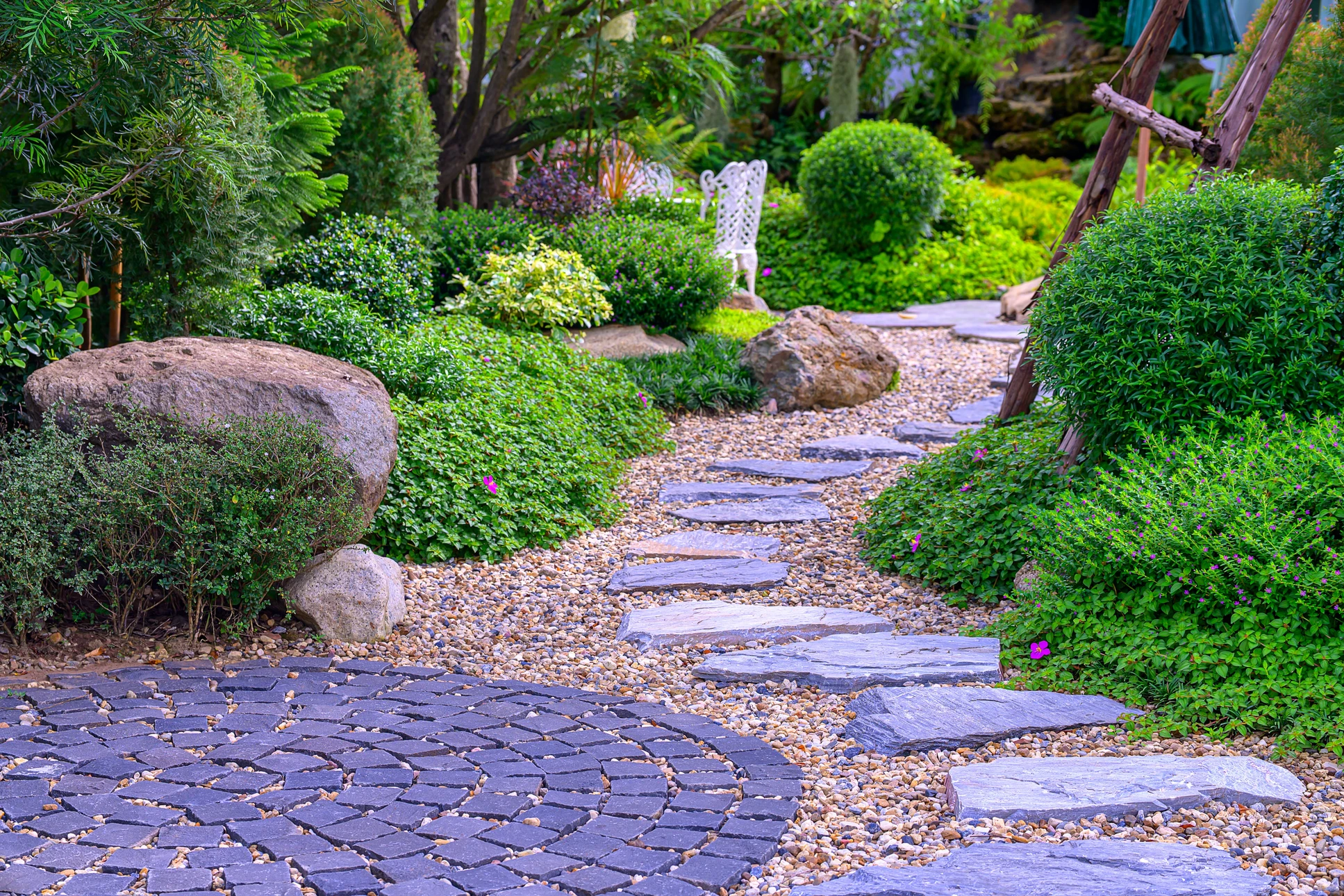 Jardinier professionnel aménageant un jardin paysager extérieur, construisant un muret en pierres naturelles